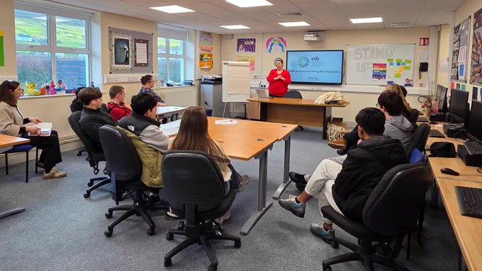 Person talking to a group of students.