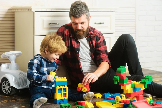Photo of child and adult playing with toys