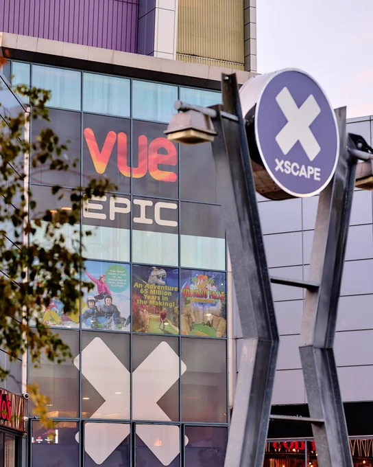 Signage for Vue Cinema and Xscape entertainment venue displayed on a modern building facade.