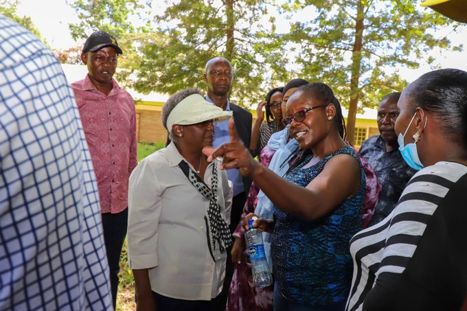 KHRC’s Mary Kambo (gesturing) speaks with NLC Commissioner Esther Murugi (wearing a white wide-brim sun visor) during a fact-finding mission on March 14, 2024, at the parcels of land claimed by the community. 