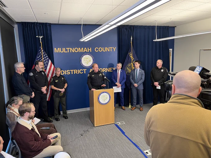 Chief Day at a podium speaking a new conference hosted by the DA.