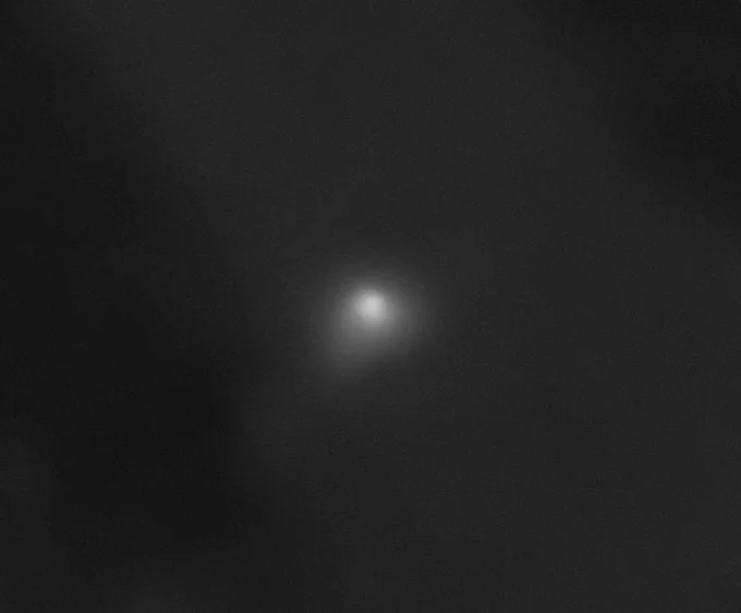 On a dark background, interstellar comet 3I/ATLAS appears as a pale smudge with a whitish core. A cloud of haze extends slightly from the comet toward the bottom left of the image and, to a lesser extent, toward the right side of the image. The High Resolution Imaging Science Experiment (HiRISE) camera aboard NASA's Mars Reconnaissance Orbiter captured this image on Oct. 2, 2025. Credit: NASA/JPL-Caltech/University of Arizona