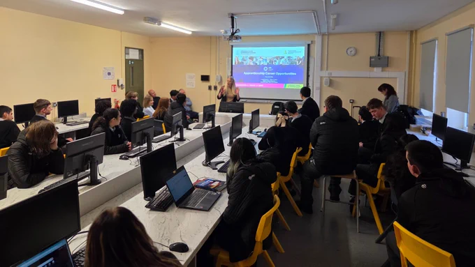 Person talking to a group of students. 