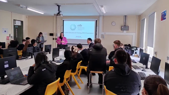 Person talking to a group of students. 