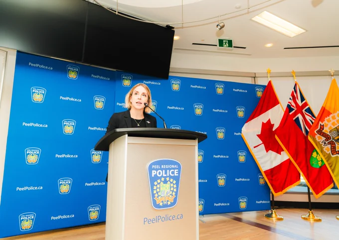 Woman speaking in front of podium with Peel Police logo