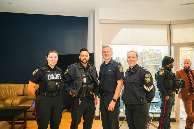 Group of Peel Police officers and Peel Police cadet posing and smiling