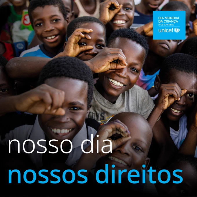 Um grupo de crianças a sorrir e a fazerem gestos com as suas mãos.
