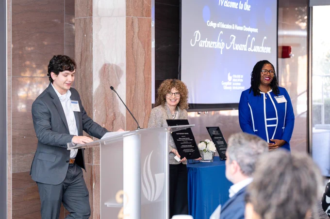 Jackson Lilly from the Office of Adult Education speaks at the podium while Regents' Professor Daphne Greenberg and Associate Dean DaShaunda Patterson listen