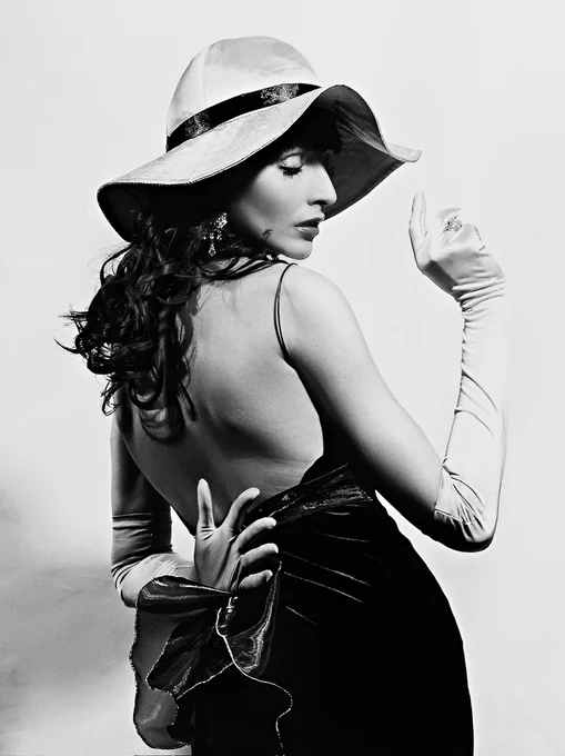 LYBO poster - b/w photography of woman wearing a wide brim hat and a black dress.
