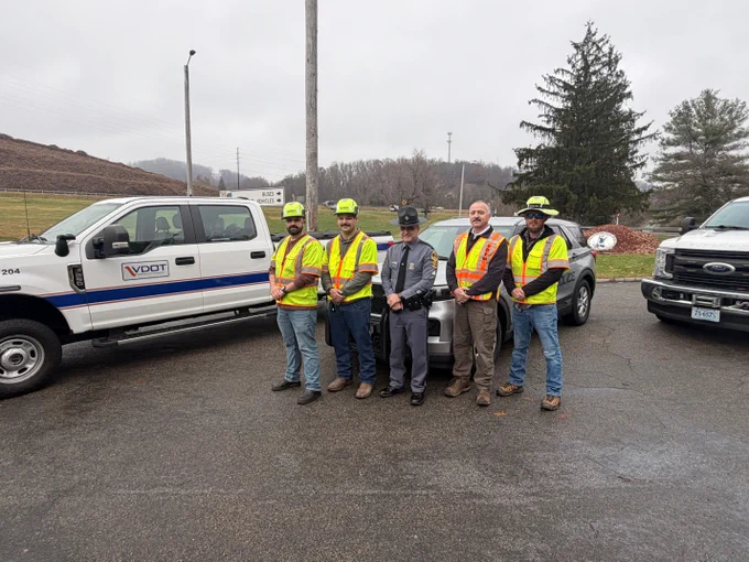 Incident response workers including Virginia State Police, Virginia Department of Emergency Management and VDOT. Some are wearing vets and helmets standing next to their emergency vehicles.