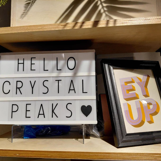 A lightbox with the words "Hello Crystal Peaks" alongside a framed photo with the words "Ey up" featured.
