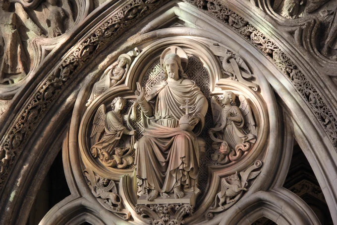 Evening sunlight falling across a stone carving of Christ in Majesty in the Chapter House at Westminster Abbey