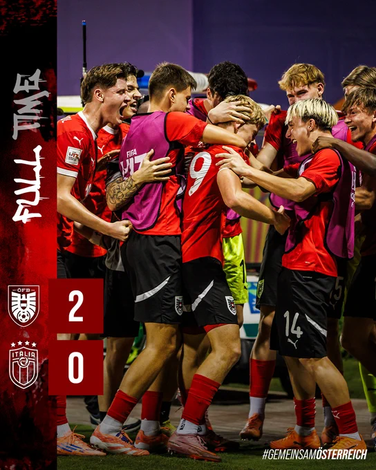 Eine Gruppe von Fußballspielern in roten Trikots feiert nach einem Sieg gemeinsam.