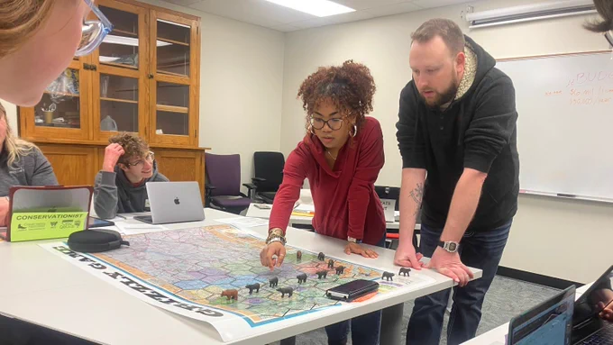 Bithiah Pulliam and Aaron Hinz strategize for the "Grizzly Game" as nearby students watch.
