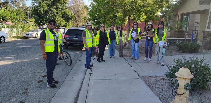A group photo of ten participants on a walk audit during a Community Pedestrian and Bicycle Safety Program training.