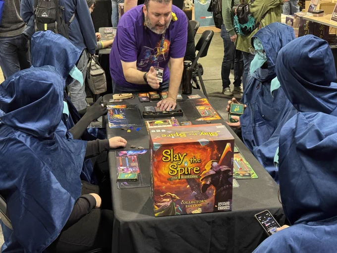 four cultist cosplayers demoing the slay the spire board game