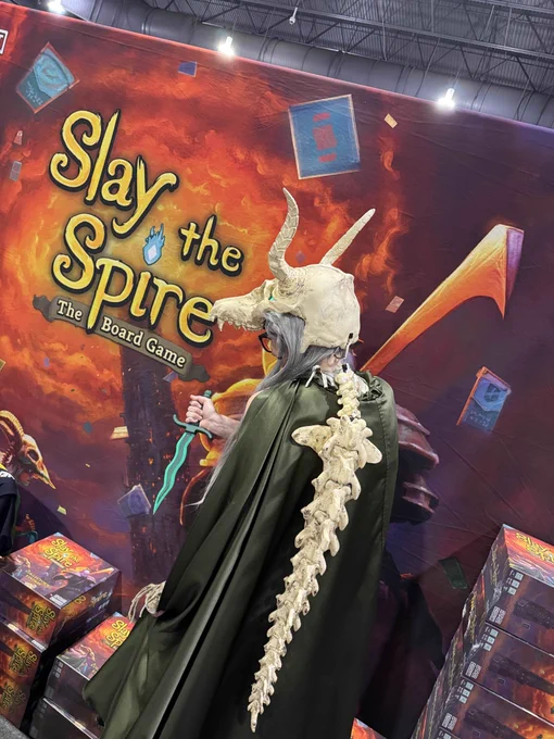 A silent cosplayer from the back posing at the slay the spire booth