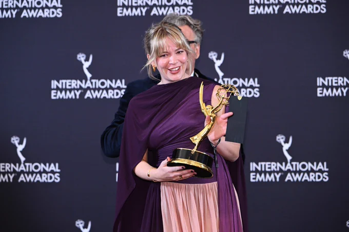 Anya Wilson holding the International Emmy trophy for Ludwig
