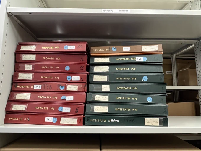 Pile of red and green books on a shelf