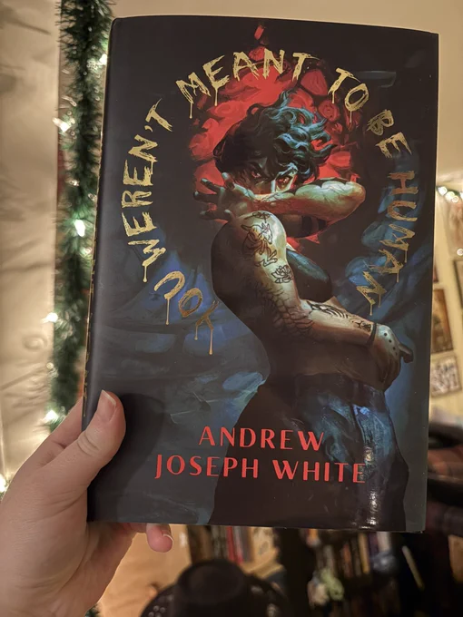 The Evernight exclusive cover of YWMTBH, showing Crane (the protagonist) in a sports bra and cargo pants, holding his pregnant stomach and covering his face while staring at the viewer. The cover is dark and claustrophobic and eerie.