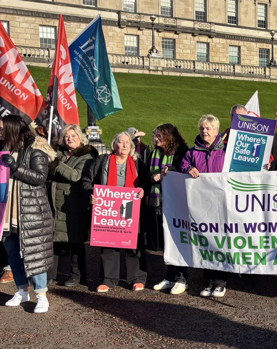 Trade union rally at Stormont, women holding banners to support workers who are victims and survivors  of domestic abuse.