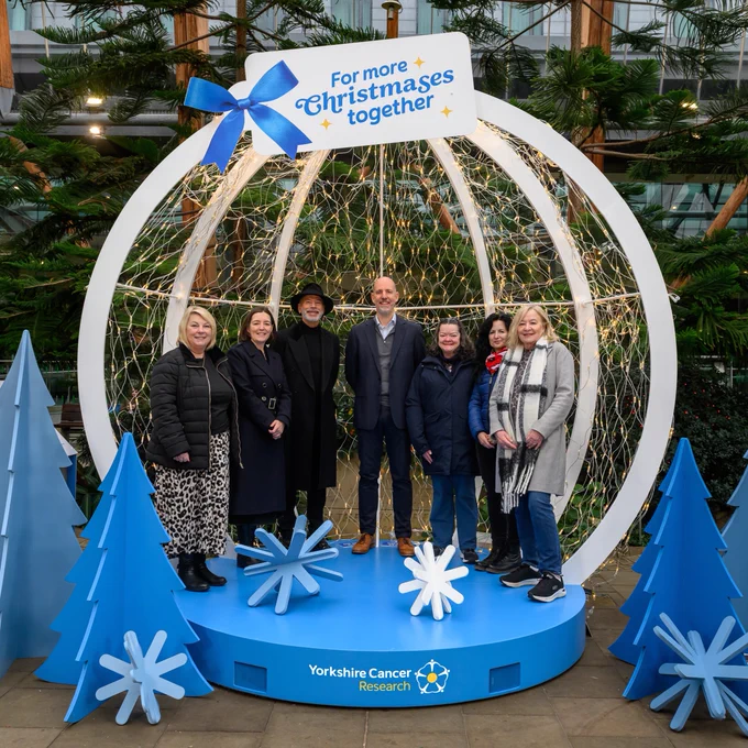 Group of seven individuals stand inside a giant snow globe with 2,600 lights, each one representing someone in Yorkshire who will be told they have cancer this Christmas. 