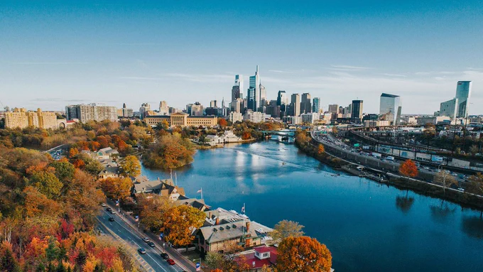 the Philadelphia skyline, with clear skies and autumn trees   