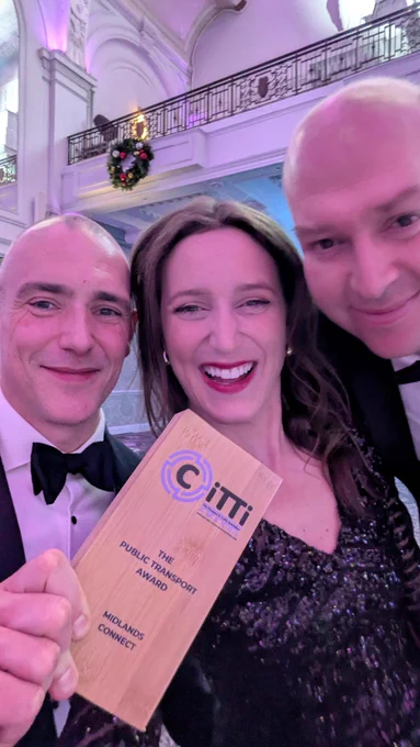 three people taking a selfie with the award