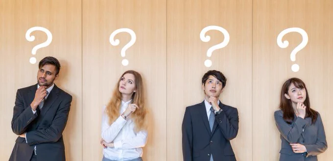 Four business professionals standing in a row, each with a thoughtful expression and a large question mark drawn above their head, symbolizing curiosity or uncertainty.