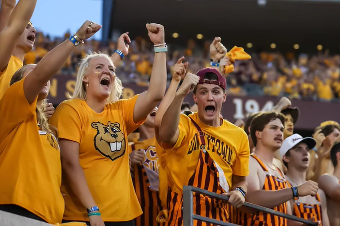 Photo of Minnesota fans wearing gold gear at a Gopher football game in 2025.