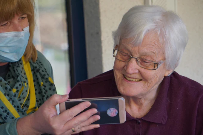 Person holiding an iphone before an elderly person