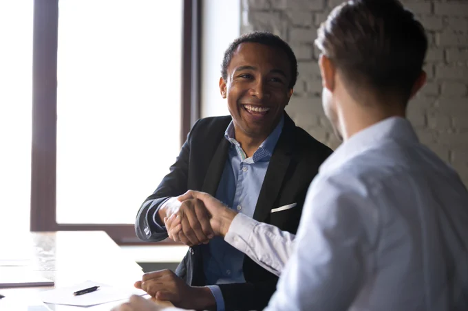 Business persons shaking hands during a meeting.jpg