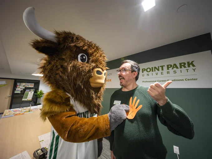 Black Diamond II, Point Park University's mascot, placing a thankful hand on Kenny Anderson, a staff person in the Professional Career Readiness Center on campus.