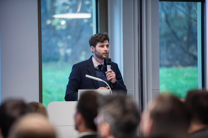 Nemo Buschmann spricht am Rednerpult mit Mikrofon vor dem Publikum der Jahrestagung der Sicherheitskooperation Cybercrime 2025.