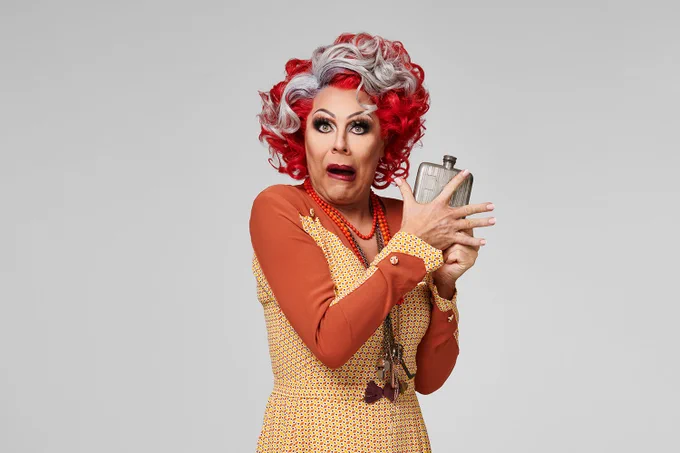 A photo showing a performer dressed in an exaggerated matron's outfit  
