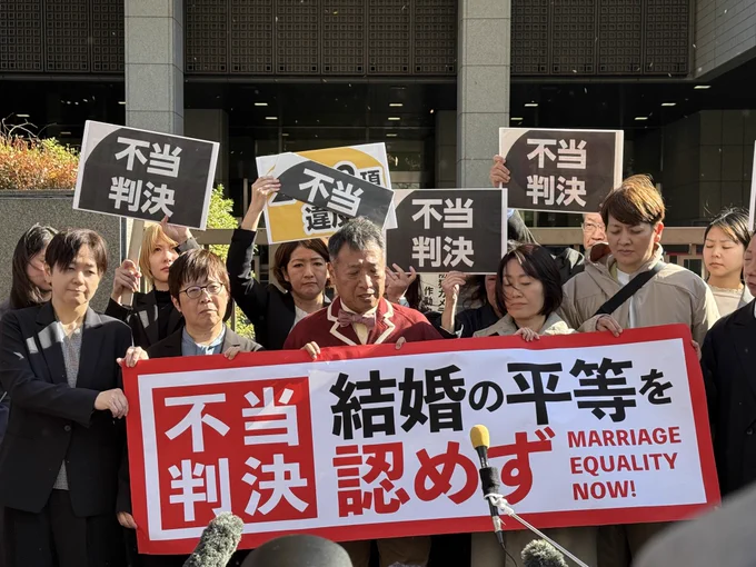 東京高裁前で「不当判決　結婚の平等を認めず」などの横断幕やブラカードを掲げる「結婚の自由をすべての人に」東京２次訴訟原告らと弁護団。全員厳しい表情。