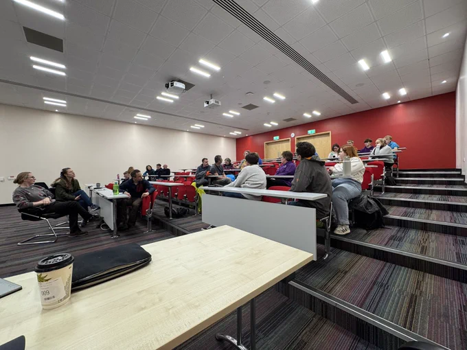 Large room with adult volunteers, some wearing casual Scout clothing