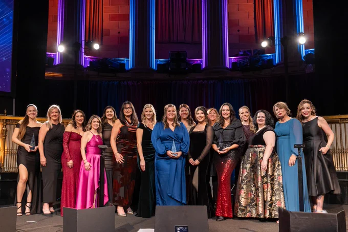 CRN's third annual (2025) Women of the Year Awards winners, CRN editors, and awards presenters from CRN's parent company, The Channel Company, dressed in black-tie attire, smile together on stage at Gotham Hall in New York City, after the winners received their awards during a gala ceremony there.