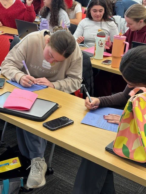 OT students writing heartfelt messages into the booklets 