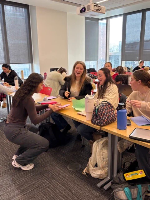 candid photo of ot students laughing and smiling as they write in the booklets