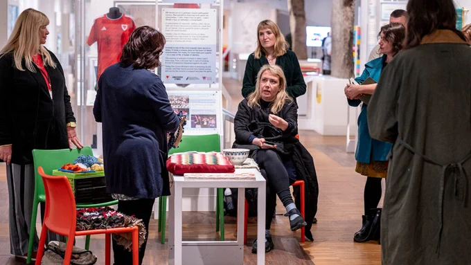 A group of people gather in a museum gallery space at St Fagans, Cardiff