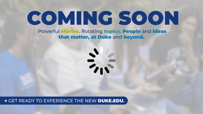 Image background features a blurred group of people engaged in discussion. Prominent text reads "COMING SOON" in large font, followed by the phrase "Powerful stories. Rotating topics. People and ideas that matter, at Duke and beyond." A loading icon is centered below the text, with a footer prompting to "GET READY TO EXPERIENCE THE NEW DUKE.EDU."