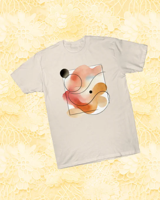 A light beige T shirt displayed against a soft yellow floral background. The shirt features an abstract watercolor style design with warm tones of orange, red and beige, accented with white areas and two black circular shapes. Thin black lines curve across the composition, creating a modern minimalist look.