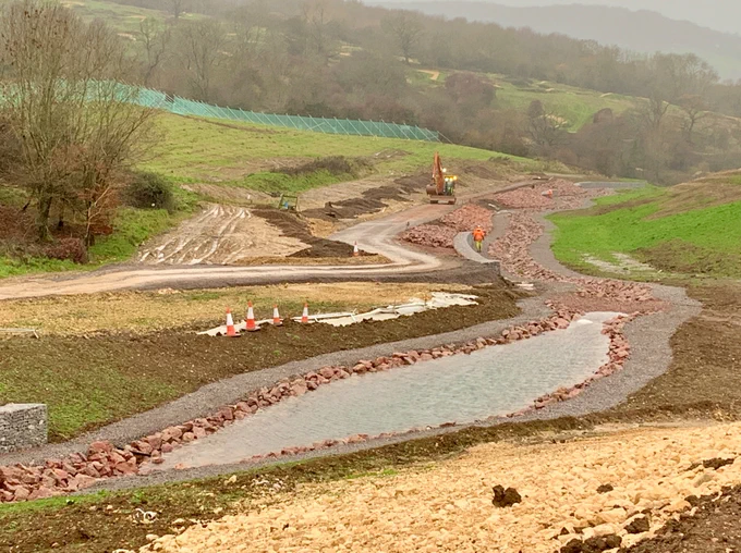Crickley Hill stream flowing with Cotswold groundwater out of the limestone principal aquifer. Design has included geomorphological features with meanders and slacker pools and riffles. Vegetation growth will colonise and naturalise the channel creating a valuable water feature in a steep gradient/ valley upland setting on Crickley Hill, Gloucestershire 