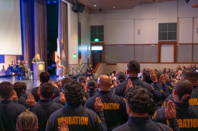 Officers raising their right hands as they take their oath during a swearing-in ceremony by the Chief Probation Officer.