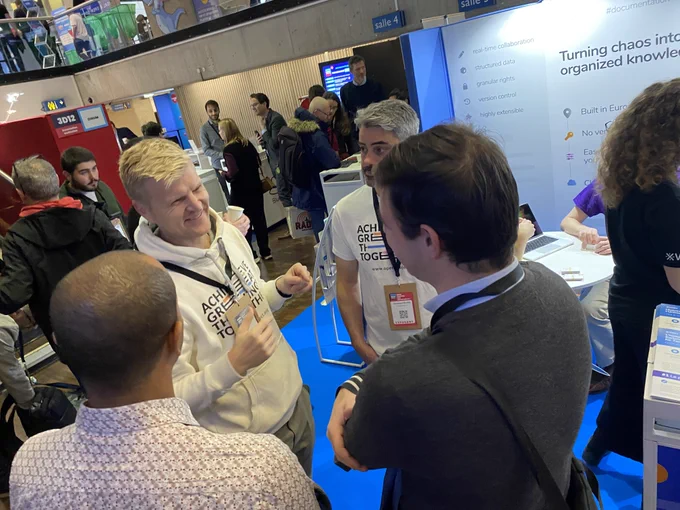 Wieland Lindenthal speaking with visitors at the busy OpenProject and XWiki booth during OSXP 2025.