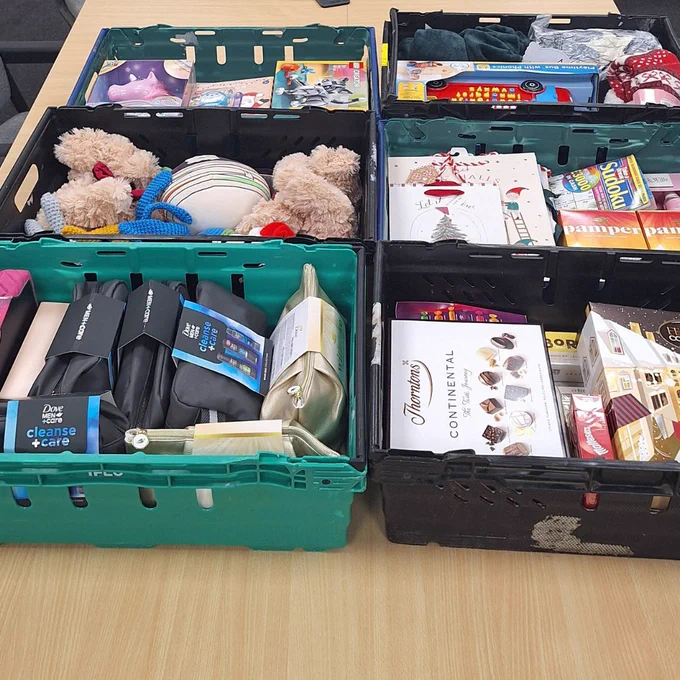 Six crates full of toiletries, chocolates, toys and biscuits.