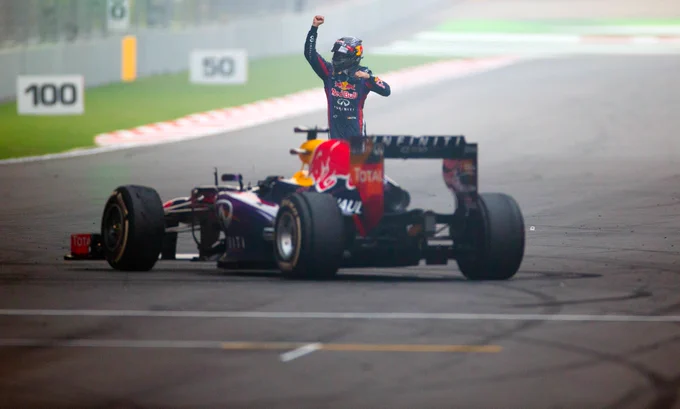 Seb celebrates by the car on track.
