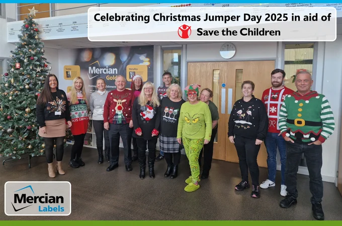 A group of people stood in front of a Christmas tree, all wearing Christmas Jumpers or festive outfits.