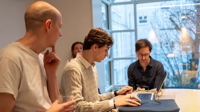 Three people looking at a laptop